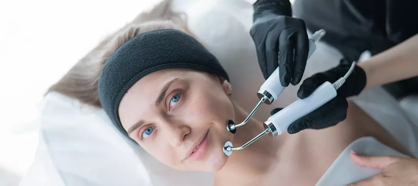A young woman having the best microcurrent facial device treatment 